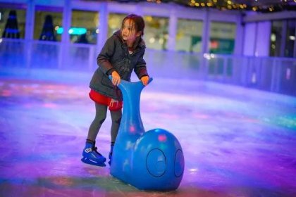 Child skating with whale aid at Willen On Ice.