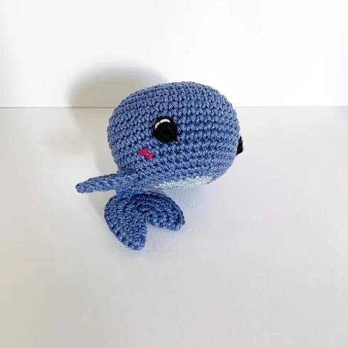 a crocheted blue octopus stuffed animal sitting on top of a table next to a white wall