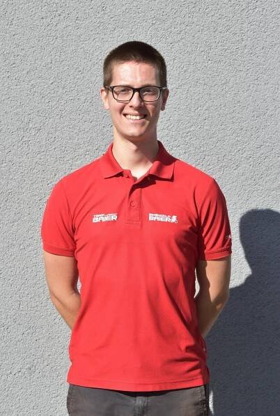 Ein junger Mann mit Brille und rotem Poloshirt