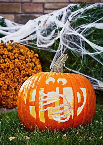 spooky help carved jack-o-lantern with skeleton hands