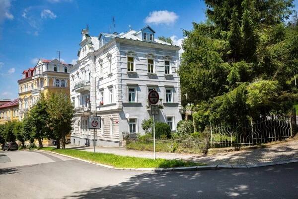 a white building on the corner of a street at Apartman Karlovarská in Mariánské Lázně
