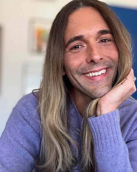 Jonathan Van Ness smiling resting their head on their hand