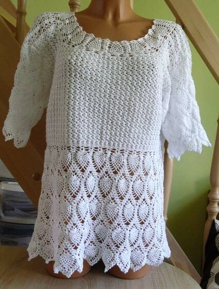 a white crocheted top sitting on top of a wooden chair next to a stair case