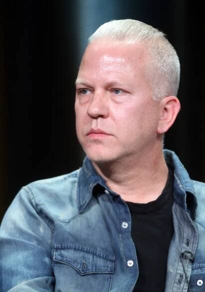 Ryan Murphy with short light hair wearing a denim shirt and a top at a public event