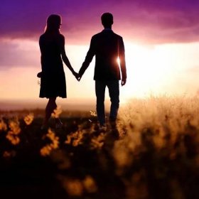 Mladý pár se těší na západ slunce na louce — Stock obrázek