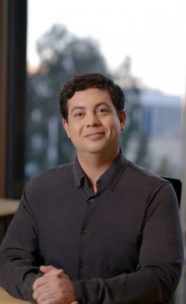 Jon Carmody, Chief Software Architect at Innfinity, seated and smiling in a dark button-up shirt.
