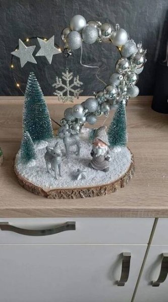 a wooden table topped with christmas decorations and silver baubles on top of it