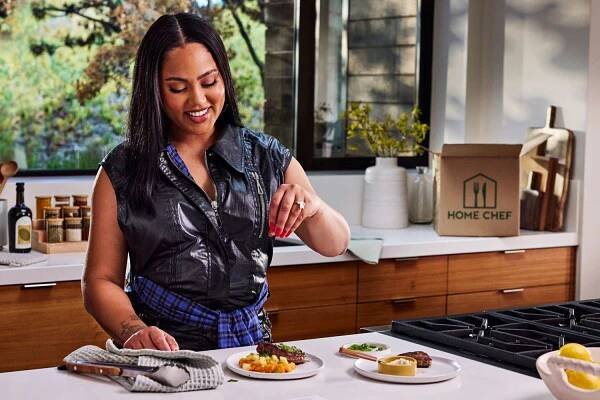 Ayesha Curry season one of her Home Chef recipes in a kitchen.