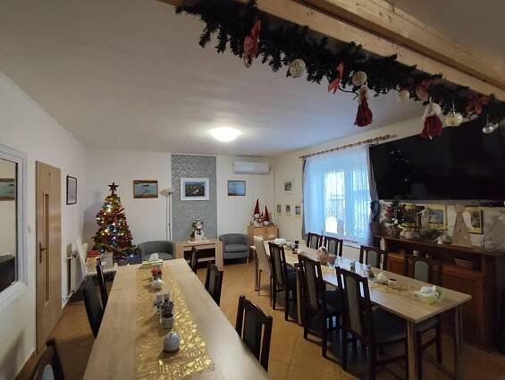 a room with a christmas tree and tables and chairs at penzion U Hájků in Křepice