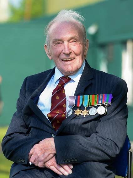 Image shows RAF Veteran wearing his medals and sitting in a chair,