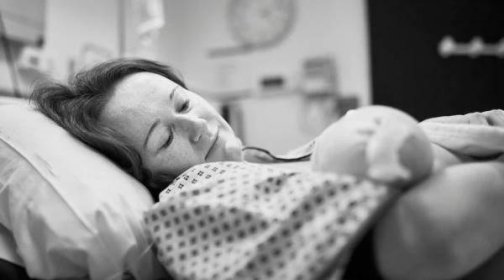 Žena drží novorozence krátce po porodu, vyvolávaný porod