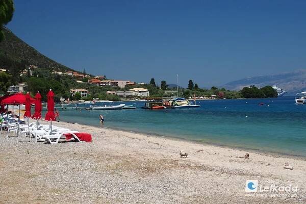 Sunbeds for rent at Paralia Nidri beach with coarse sand and calm sea in Lefkada