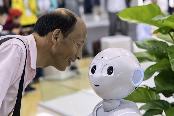 An attendee looks at a CloudMinds Technology’s Cloud Pepper semi-humanoid robot at the World Artificial Intelligence Conference in Shanghai in August. Photo: Bloomberg