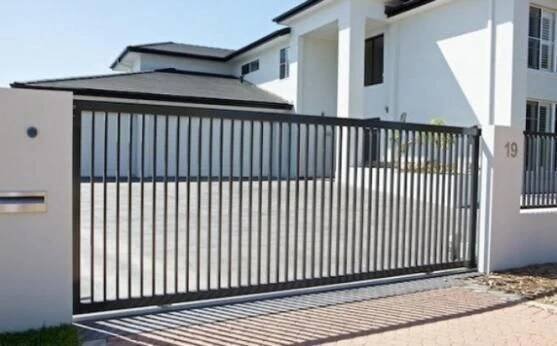 a white house with a black gate in front of it