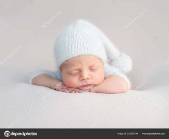 Stáhnout - Roztomilé miminko v bílém klobouku a pletené obleku sladce spí — Stock obrázek