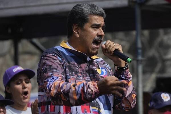 A man holding a microphone speaks to a crowd