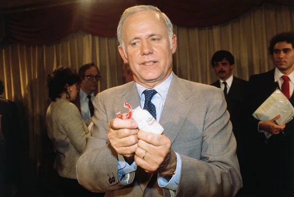 James Burke, a Johnson & Johnson executive, displays a new Tylenol bottle.