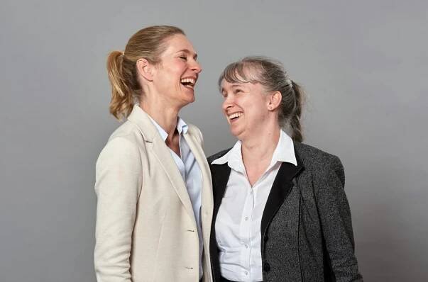 Lisa Martinek und Pamela Pabst stehen zueinander gewandt und lachen herzlich.