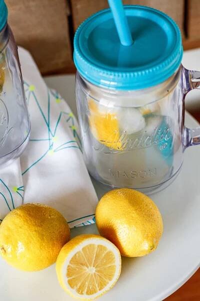 lemon shake up in a mason jar cup with a turquoise straw and lid
