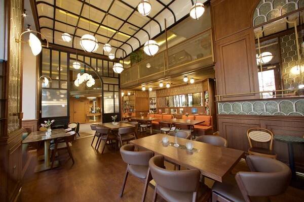 A restaurant with tables and chairs and a balcony.