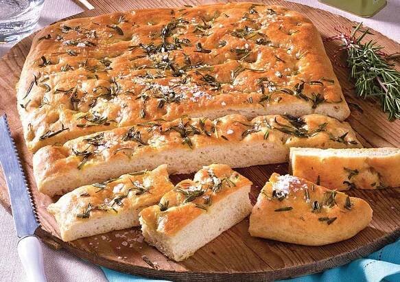 rosemary focaccia bread recipe: loaf cut on serving board