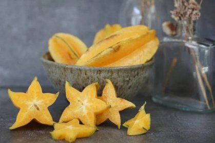Yellow starfruit in bowl and cut star-shaped pieces