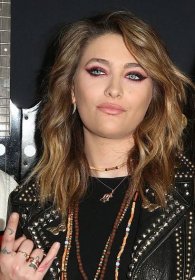 Paris Jackson showing her many finger tattoos as she throws up devil horns