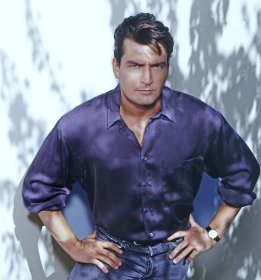 Charlie Sheen poses in a purple shirt.