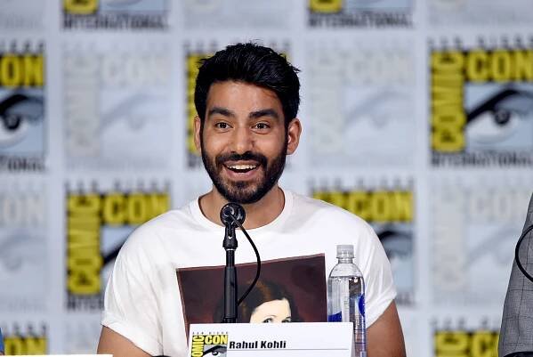 Rahul Kohli sits on a Comin Con panel. 