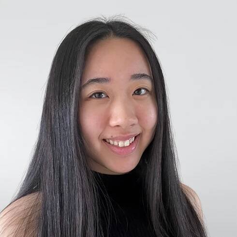 A young woman with long black hair is smiling for the camera.