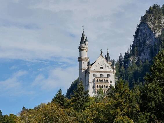 Das Schloss Neuschwanstein mit Turmspitze umgeben von Bäumen