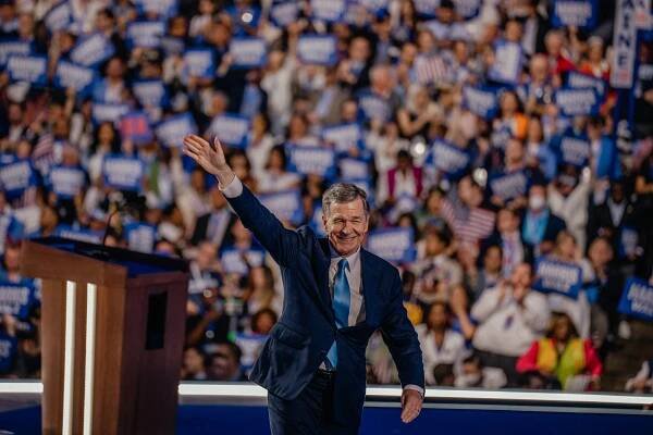 Gov. Roy Cooper of North Carolina smiling and waving to the crowd at the Democratic National Convention.