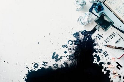 Header with spilled ink, crumpled paper, scattered letters, papers and notepads on a white wooden background. Creative writing concept. Flat lay with copy space.