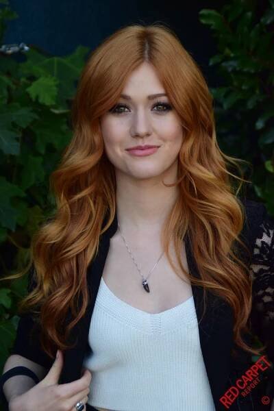 a woman with long red hair posing for a photo