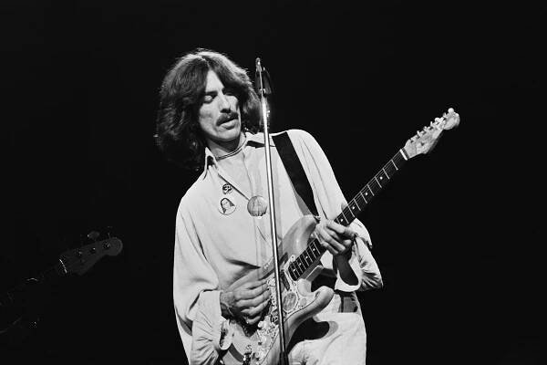 English musician, singer-songwriter, and producer George Harrison (1943 - 2001) performing on stage playing his 'Rocky' Sonic Blue Fender Stratocaster during his 'George Harrison and Ravi Shankar's 1974 North American tour' also known as the 'Dark Horse Tour' in North America, 1974. (Photo by Steve Morley/Redferns/Getty Images)