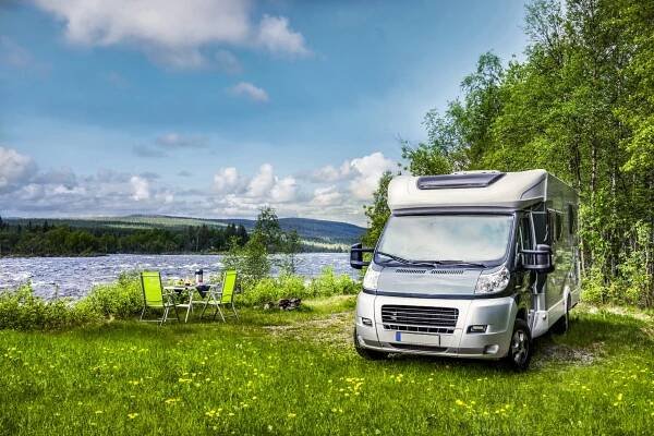 Motorhome on river with camping table