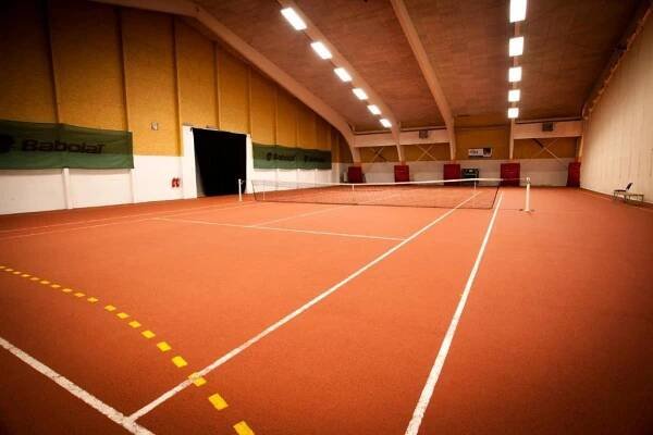 a tennis court with a net in a building at Hotel Arena Liberec in Liberec
