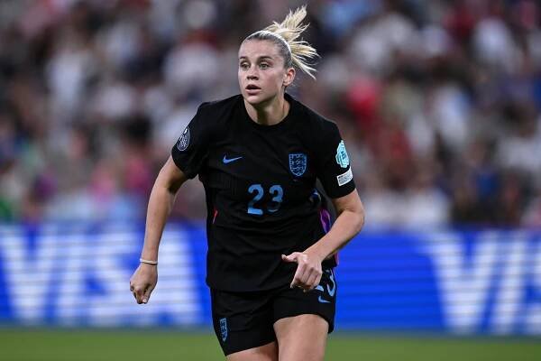 Soccer player in action, wearing a black jersey with the number 23, looking focused during a match