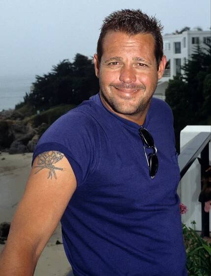 a man in a blue shirt has a tattoo on his arm