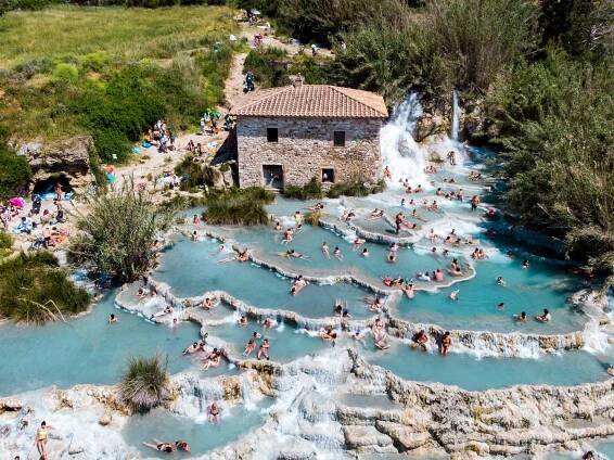 visit the saturnis hot springs: blue water and crowds of people
