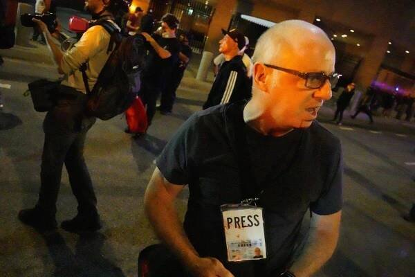 Photojournalist Nicholas Stern has blood on his face and press pass after being hit by LAPD officers 