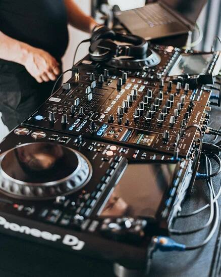 Free Professional DJ operating modern mixing equipment during an indoor event. Stock Photo