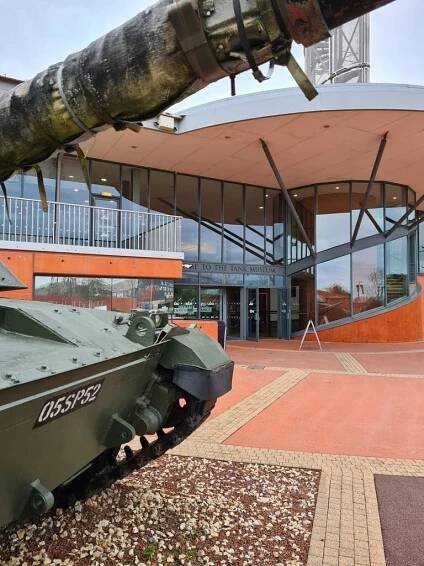 A tank outside of a modern building