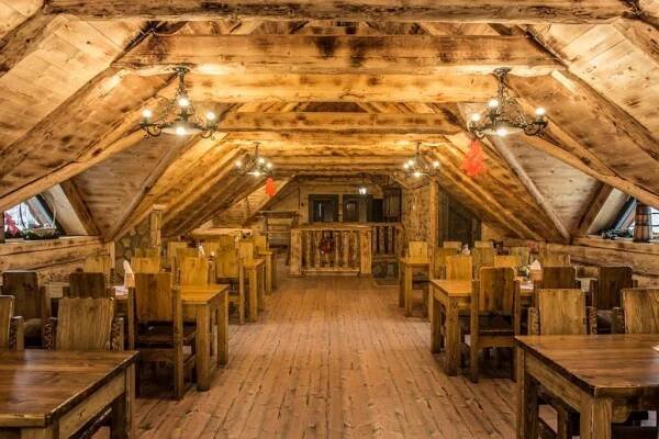 a dining room with wooden tables and chairs at Koliba Bešeňovka in Bešeňová