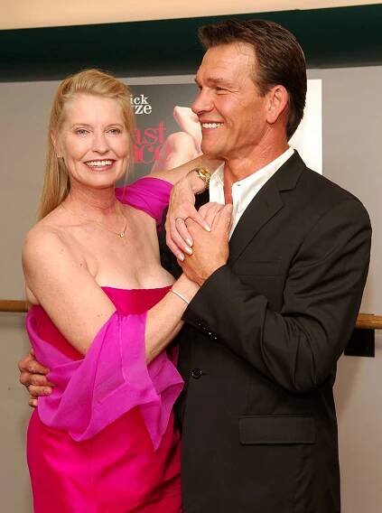 Patrick Swayze in Black Suit and Wife Lisa Niemi Swayze in Strapless Red Dress With Pink Shawl