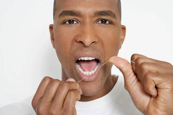 a man flossing teeth as instructed by a Dentist Fort in Lauderdale 