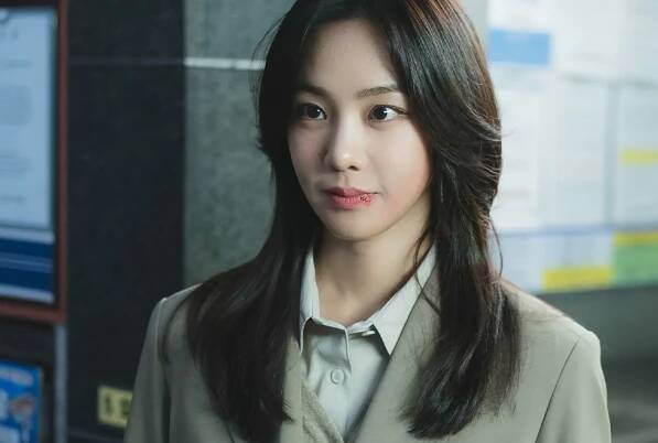 A woman with a bruised lip (Han Ji-eun as Lee Han-gyeong) stands in front of bulletin boards, in the K-drama 'Study Group.'