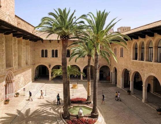 Palma De Mallorca Royal Palace Of La Almudaina Stone Buildings Interior Courtyard With Palm Trees And Tourists