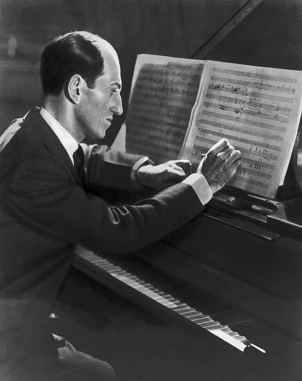 George Gershwin composing a tune at the piano