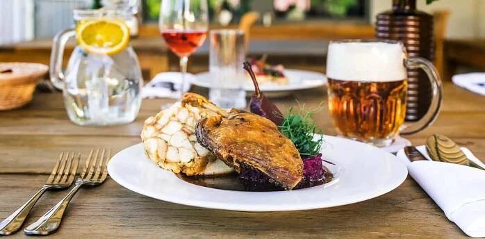 Pečená kachna s houskovým knedlíkem na stole v restauraci DEPO v Českém Krumlově